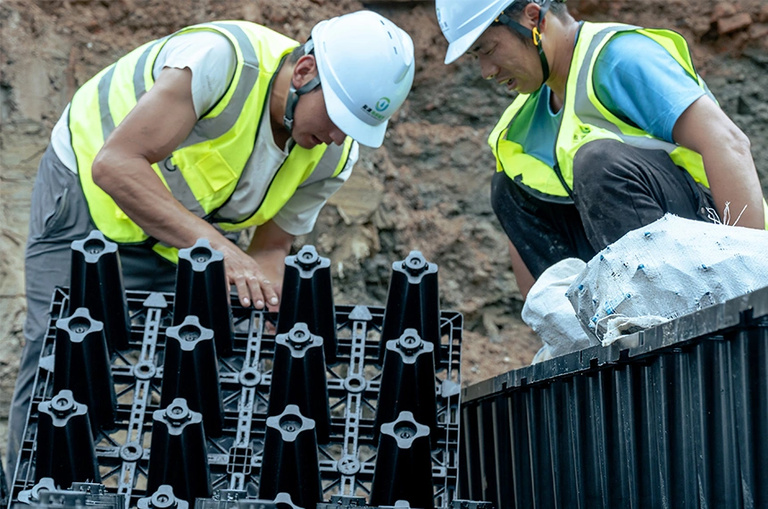 正在上传... Workers assembling interlocking PP rainwater harvesting modules at an underground installation site