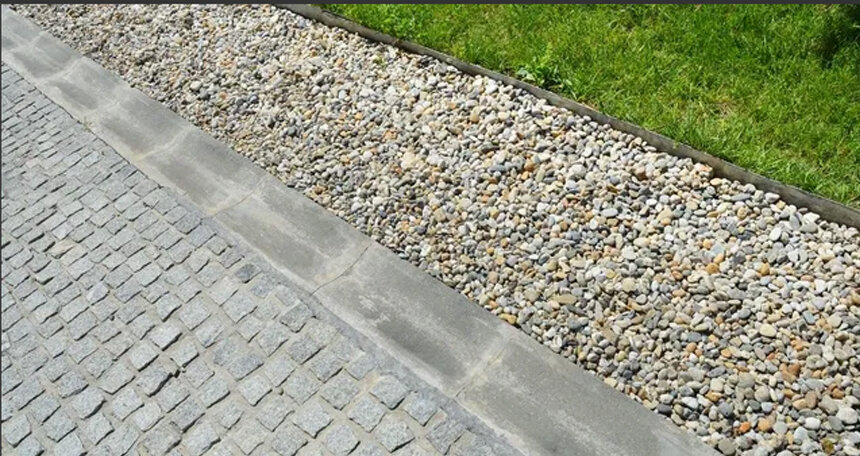 Aproximação de pedras de pavimento permeável e vala de infiltração adjacente de cascalho concebida para drenagem urbana sustentável